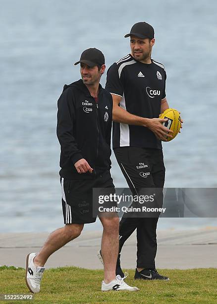 Alan Didak and Chris Dawes of the Magpies walk along the beach during a Collingwod Magpies AFL recovery sessionat the St Kilda Sea Baths on September...