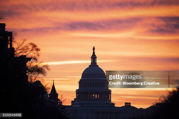 the us capitol building against an orange sky - washington dc sunset stock pictures, royalty-free photos & images