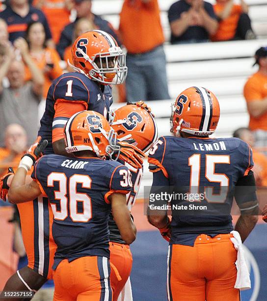 Ashton Broyld of the Syracuse Orange celebrates after a touchdown with teammates Christopher Clark, Alec Lemon and Macky MacPherson during the game...