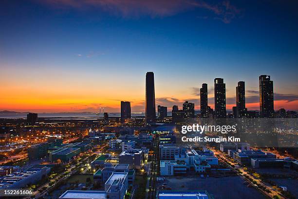 cityscape with skyscraper at sunset - songdo ibd stock-fotos und bilder