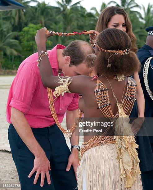 Young girl presents Prince William, Duke of Cambridge with a garland as they arrived in Honiara on their way to Tivanipupu on day 7 of their Diamond...