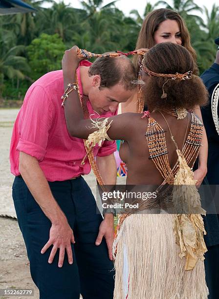 Young girl presents Prince William, Duke of Cambridge with a garland as they arrived in Honiara on their way to Tivanipupu on day 7 of their Diamond...