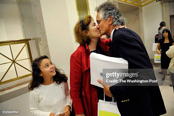 Dominique Bagnato, right, of France is greeted by his wife, Tesa Conlin, center, as daughter, Bliss Bagnato-Conlin left, looks on following a...