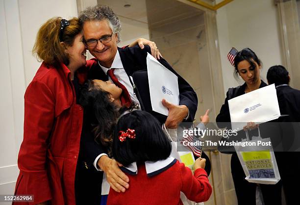 Dominique Bagnato, top center, of France is greeted by his wife, Tesa Conlin, left, and daughters, Bliss Bagnato-Conlin middle left center, and Mila...