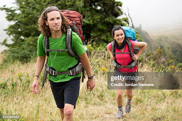 a man and woman backpacking. - lincoln city oregon stock pictures, royalty-free photos & images