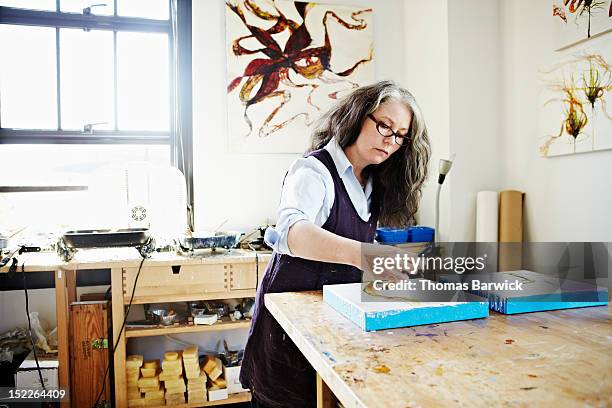 female painter working on painting in studio - woman painting stock pictures, royalty-free photos & images
