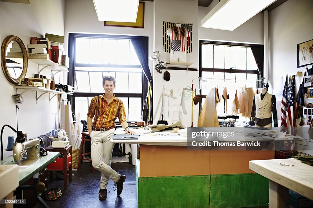 Male fashion designer standing in studio smiling