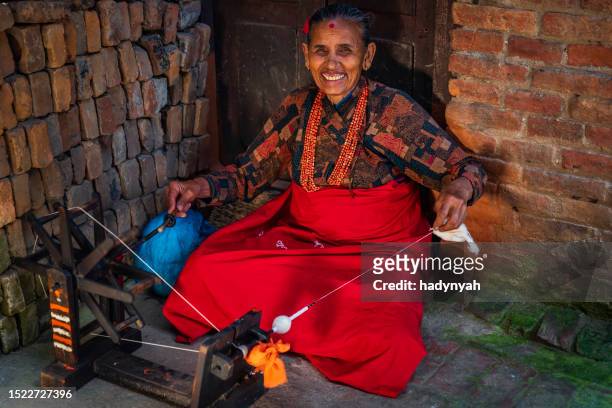 nepali woman spinning a wool in an ancient town of bhaktapur, nepal - spinning wool stock pictures, royalty-free photos & images
