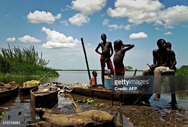 Boys from the Mandari tribe wait by the Nile river for boats with the day's catch to arrive in Terekeka, a fishing community 75km north of Juba in...