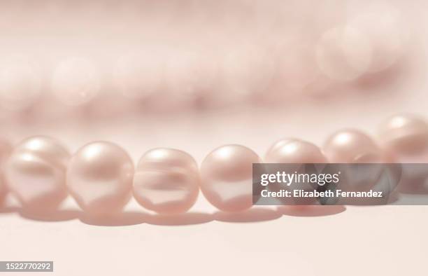 macro of pink pearls, brightly lit. - fashion glamour pearl stock pictures, royalty-free photos & images