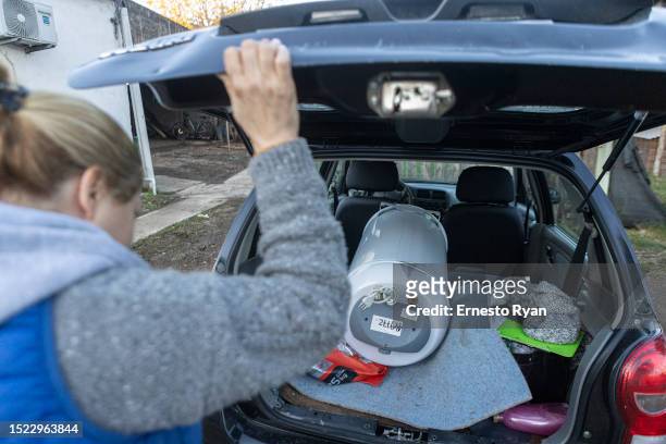 Woman loads a water heater to her car after its repair as a demand in their repairs surges due to the high salinity in the tap water which causes...