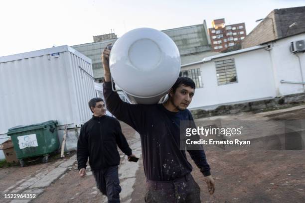 Man carries a water heater to repair as a demand in their repairs surges due to the high salinity in the tap water which causes damages to the...