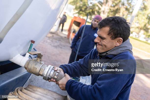 Worker of OSE connects a tank truck to a water bomb which pumped underground water that is drinkable to supply hospitals on July 07, 2023 in...
