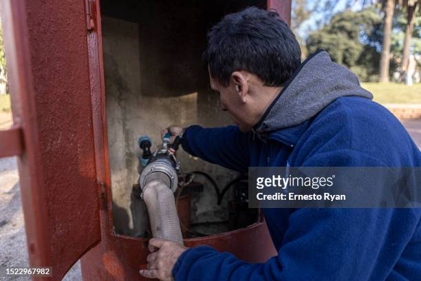 Worker of OSE connects a tank truck hOSE to a water bomb which pumped underground water that is drinkable to supply hospitals on July 07, 2023 in...