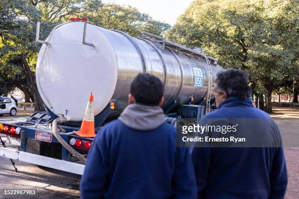 Workers of OSE check on a tank truck that is connected to a water bomb which pumped underground water that is drinkable to supply hospitals on July...