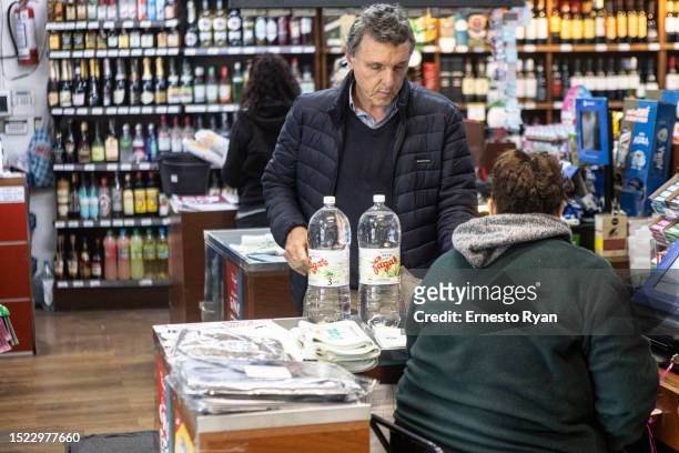 Man buys bottled water in a supermarkets as tap water contains high salinity and chemicals on July 06, 2023 in Montevideo, Uruguay. The country faces...