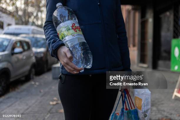 Person holds a bottle of water due to the high salinity and chemicals from tap water on July 06, 2023 in Montevideo, Uruguay. The country faces its...