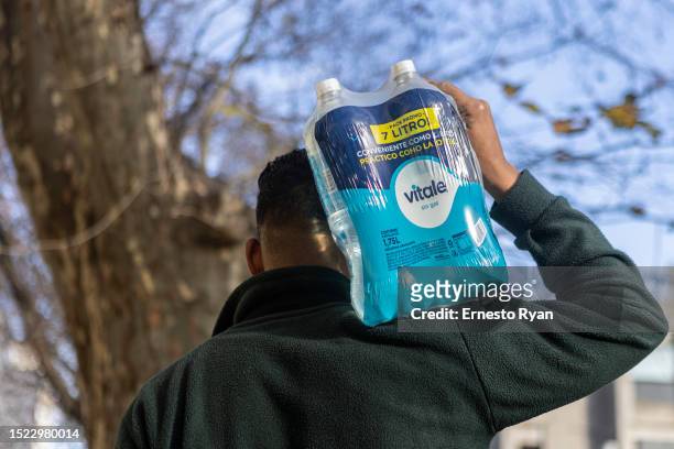 Delivery man carries a bottle water package as tap water contains high salinity and chemicals on July 06, 2023 in Montevideo, Uruguay. The country...