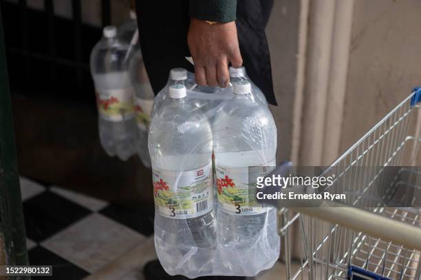 Delivery man carries a bottle water packages as tap water contains high salinity and chemicals on July 06, 2023 in Montevideo, Uruguay. The country...
