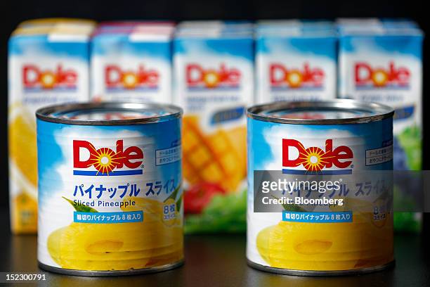 Cans of Dole Food Co. Sliced pineapple are arranged for a photograph in front of cartons of the company's fruit juice in Soka City, Saitama...