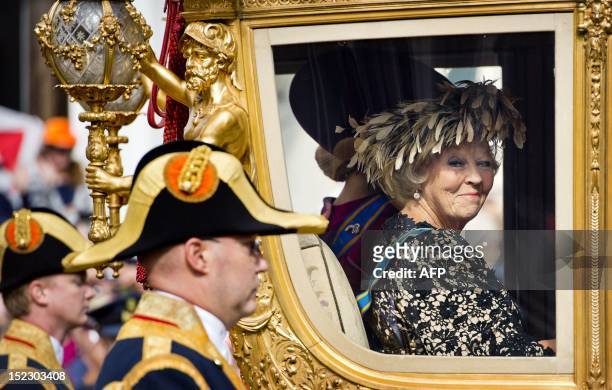Queen Beatrix of The Netherlands looks on from the Golden Carriage as she leaves Noordeinde Palace for a ride to the Ridderzaal in The Hague on...
