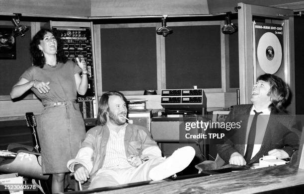 Swedish singer Anni-Frid Lyngstad, Benny Andersson and Björn Ulvaeus, of the Swedish supergroup ABBA, play his guitar at Polar Studios in Stockholm,...