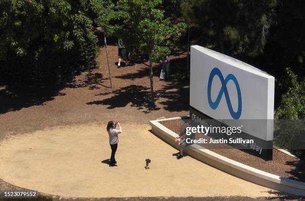 In an aerial view, people gather in front of a sign posted at Meta headquarters on July 07, 2023 in Menlo Park, California. Since launching, Meta's...