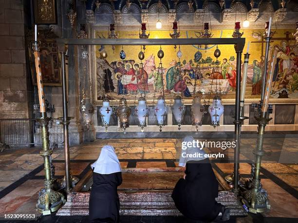 der stein der salbung in der grabeskirche, jerusalem mit nonne - jesus entry into jerusalem stock-fotos und bilder