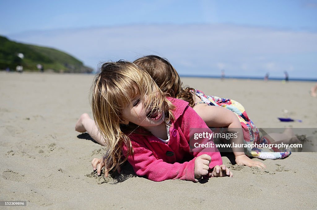 Sisters wrestling on beach