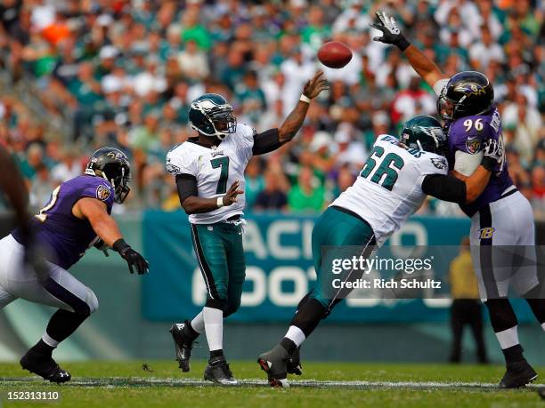 Quarterback Michael Vick of the Philadelphia Eagles makes a pass as teammate Dallas Reynolds blocks Maake Kemoeatu of the Baltimore Ravens as Haloti...