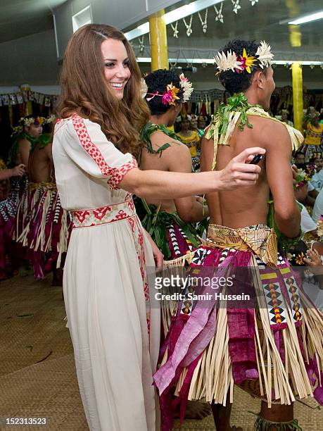 Catherine, Duchess of Cambridge sprays perfume on traditional dancers at the Vaiku Falekaupule for an entertainment programme during the Royal...