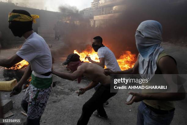 Smoke billows from burning tyres as Palestinian protesters prepare to throw stones towards Israeli security forces during clashes that erupted after...