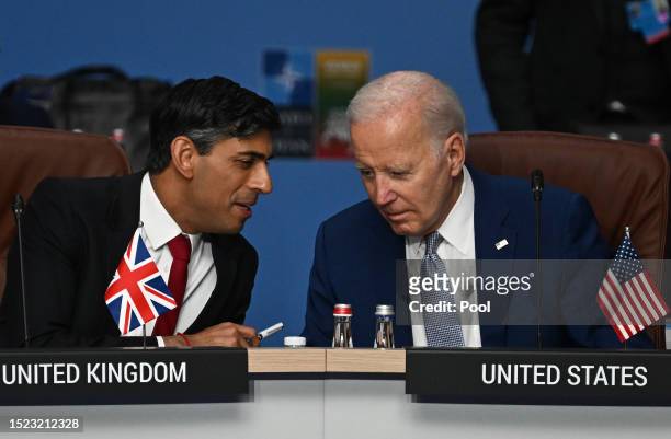 Britain's Prime Minister Rishi Sunak and US President Joe Biden speak at the start of the meeting of the North Atlantic Council on the first day of...