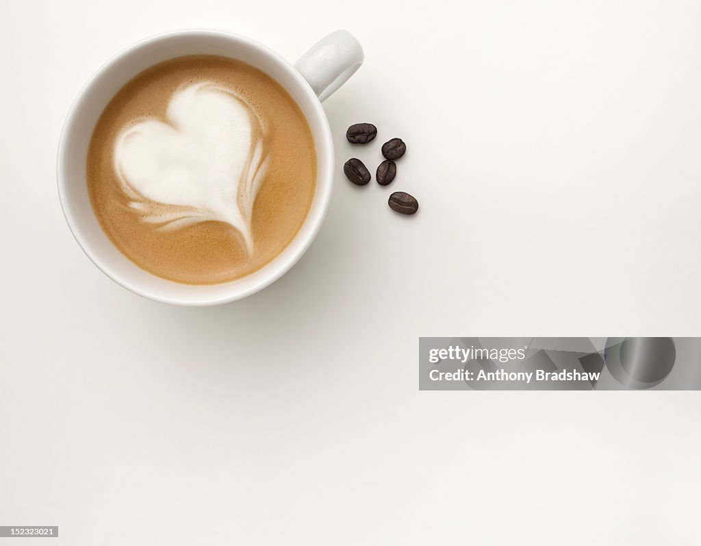 A coffee with a heart shape drawn in its foam