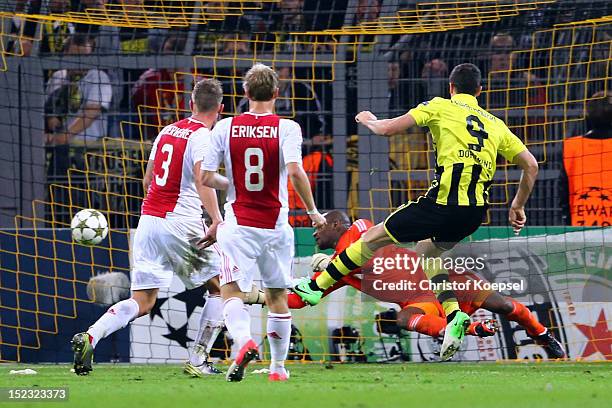 Robert Lewandowski of Dortmund scores the first goal against Kenneth Vermeer , Toby Alderweireld and Chrisitian Eriksen of Amsterdam during the UEFA...