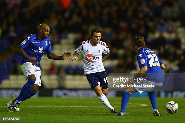 Mark Davies of Bolton Wanderers passes as Marlon King and Jonathan Spector of Birmingham City close in during the npower Championship match between...