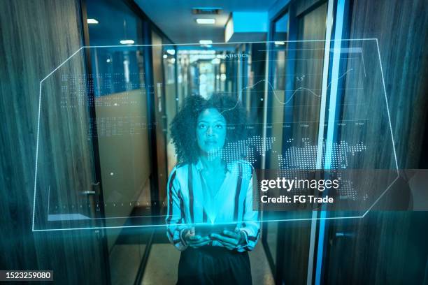 mujer joven usando dispositivo de realidad aumentada en la oficina - holographic-map fotografías e imágenes de stock