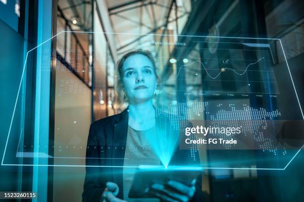 mujer mediana adulta usando un dispositivo de realidad aumentada en la oficina - holographic-map fotografías e imágenes de stock