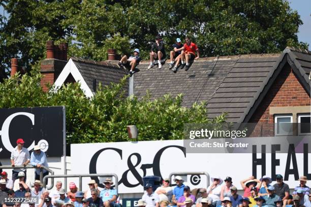 Cricket fans watch the action from a nearby roof of a house during day two of the LV= Insurance Ashes 3rd Test Match between England and Australia at...