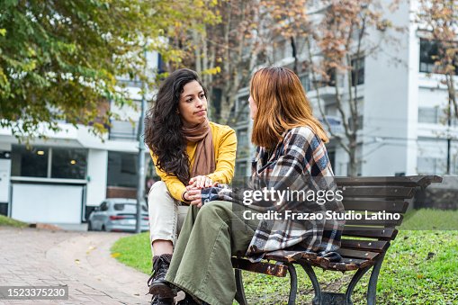 Young woman consoling her friend on the public park Young woman consoling her friend on the public park