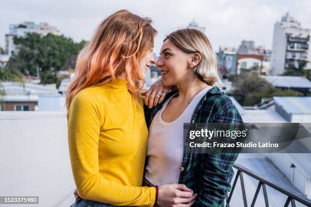 giovane coppia lesbica che strofina il naso al balcone dell'appartamento - lesbica foto e immagini stock