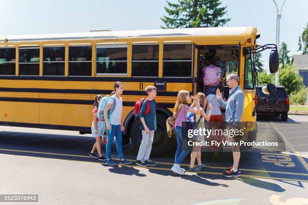 teacher giving students high five after school - viagem-de-estudo imagens e fotografias de stock