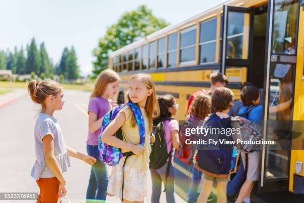 elementary age kids boarding their school bus - kids lining up stock pictures, royalty-free photos & images
