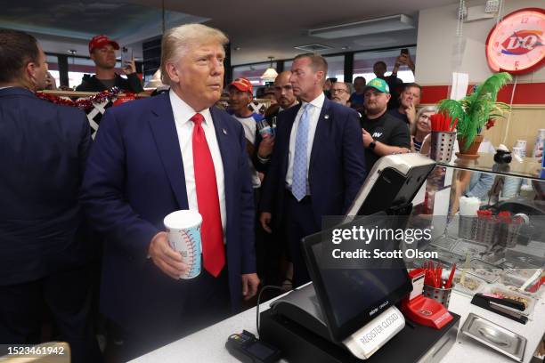 Former President Donald Trump grabs a milkshake for himself before leaving a DQ restaurant where he passed out Blizzards and milkshakes to guests on...