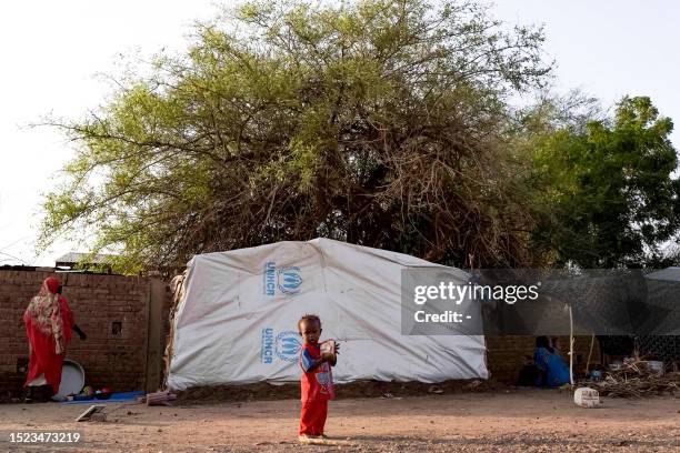 An internally displaced child stands outside a tent pitched at the Hasahisa secondary school on July 10 which has been made into a make-shift camp to...