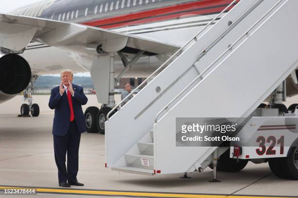 Former US President Donald Trump prepares to board his jet at the airport after holding a campaign event in Nearby Council Bluffs, Iowa on July 07,...