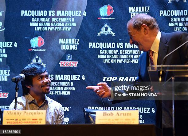 Boxer Manny Pacquiao talks with promoter Bob Arum at a press conference September 19, 2012 in New York to promote Pacquiao's December 8 welterweight...