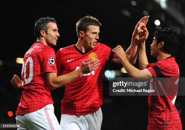 Michael Carrick of Manchester United celebrates with Robin van Persie and Shinji Kagawa as he scores their first goal during the UEFA Champions...