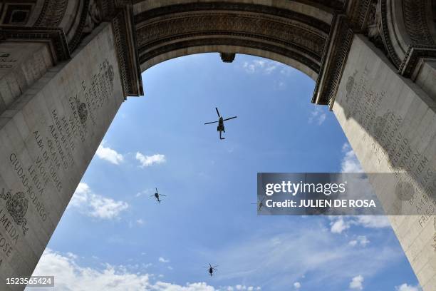 Four French Army helicopters, a Puma , a Fennec Canon and a Fennec followed by an H160 Guepard fly over the Arc de Triomphe during a rehearsal, three...