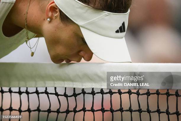 Ukraine's Elina Svitolina kisses the net as she plays against Poland's Iga Swiatek during their women's singles quarter-finals tennis match on the...